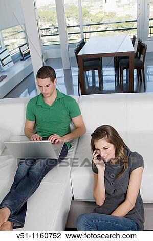 Stock Image - Portrait of a couple enjoying leisure time at home. Fotosearch
