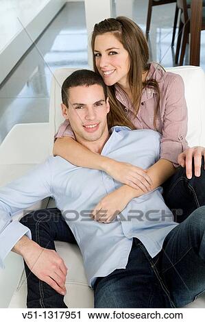 Portrait of a couple in sofa smiling at camera View Large Photo Image Stock Image - Portrait of a couple in sofa smiling at camera. Fotosearch