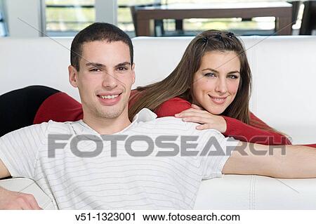 Portrait of a couple in sofa smiling at camera View Large Photo Image Stock Image - Portrait of a couple in sofa smiling at camera. Fotosearch