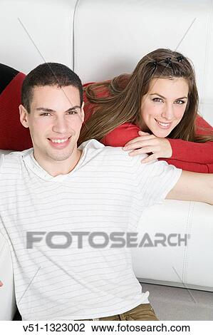 Portrait of a couple in sofa smiling at camera View Large Photo Image Stock Image - Portrait of a couple in sofa smiling at camera. Fotosearch