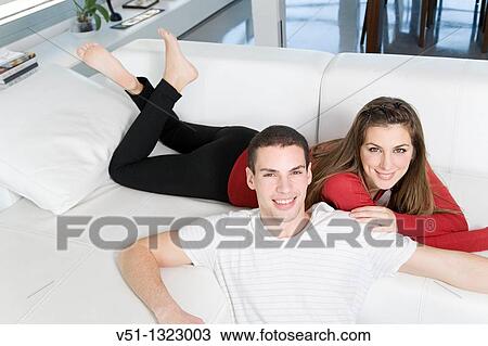 Portrait of a couple in sofa smiling at camera View Large Photo Image Stock Image - Portrait of a couple in sofa smiling at camera. Fotosearch