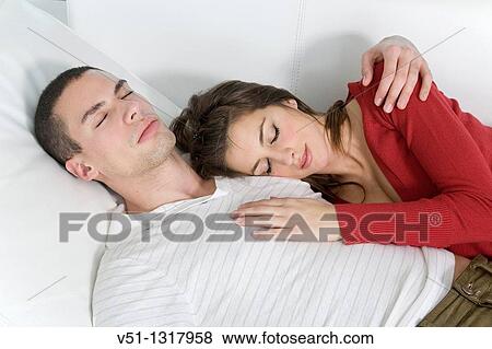 Portrait of a couple relaxing in sofa View Large Photo Image Stock Photo - Portrait of a couple relaxing in sofa. Fotosearch