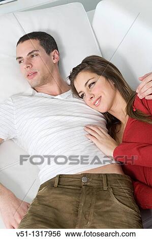 Stock Photograph - Portrait of a couple relaxing in sofa. Fotosearch