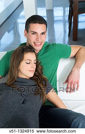 Portrait of a couple relaxing in sofa View Large Photo Image Stock Photography - Portrait of a couple relaxing in sofa. Fotosearch