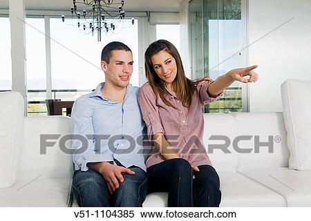 Portrait of a couple sitting on the sofa View Large Photo Image Stock Photography - Portrait of a couple sitting on the sofa. Fotosearch
