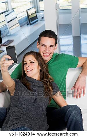 Portrait of a couple taking a self-portrait at home View Large Photo Image Picture - Portrait of a couple taking a self-portrait at home. Fotosearch