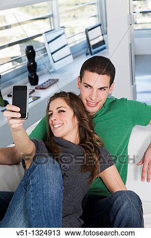 Portrait of a couple taking a self-portrait at home View Large Photo Image Stock Image - Portrait of a couple taking a self-portrait at home. Fotosearch
