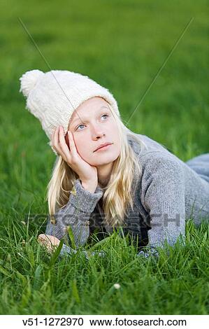 Portrait of a daydreaming woman lying down in the park View Large Photo Image Stock Image - Portrait of a daydreaming woman lying down in the park. Fotosearch