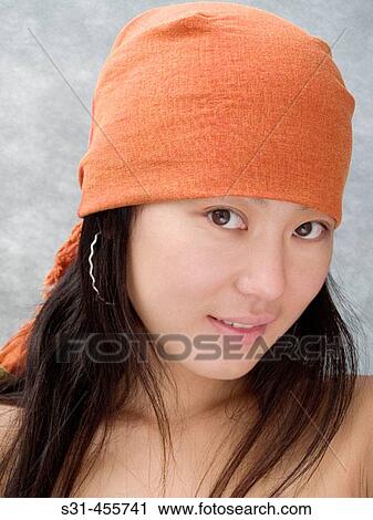 Stock Image - Portrait of a good looking asian girl, topless, wearing an orange bandana. Fotosearch