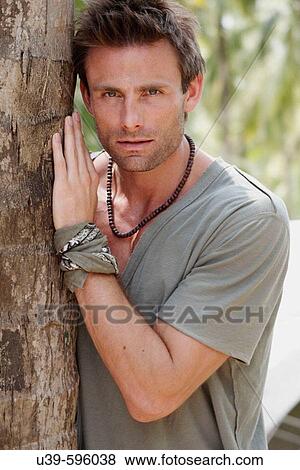 Portrait of a good-looking man leaning against a tree in India. View Large Photo Image Stock Photo - Portrait of a good-looking man leaning against a tree in India.. Fotosearch