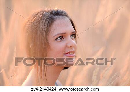 Portrait of a good looking young woman in the reeds at sunset in early spring. View Large Photo Image Picture - Portrait of a good looking young woman in the reeds at sunset in early spring.. Fotosearch