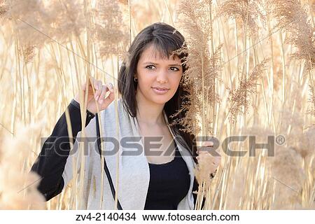 Portrait of a good looking young woman in the reeds on a sunny day in early spring. View Large Photo Image Picture - Portrait of a good looking young woman in the reeds on a sunny day in early spring.. Fotosearch