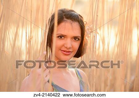 Portrait of a good looking young woman in the reeds at sunset in early spring. View Large Photo Image Stock Image - Portrait of a good looking young woman in the reeds at sunset in early spring.. Fotosearch