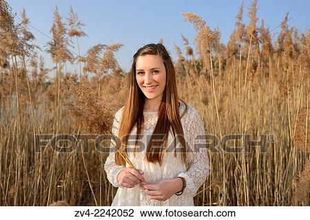 Portrait of a good looking young woman in the reeds on a sunny day in early spring. View Large Photo Image Stock Image - Portrait of a good looking young woman in the reeds on a sunny day in early spring.. Fotosearch