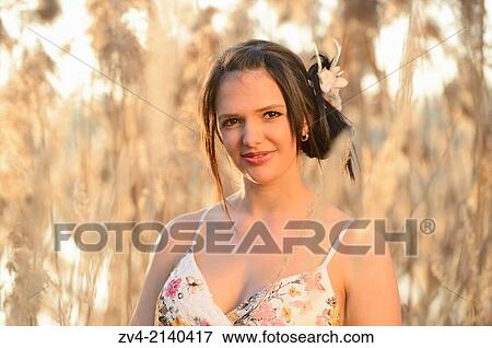 Portrait of a good looking young woman in the reeds at sunset in early spring. View Large Photo Image Stock Photo - Portrait of a good looking young woman in the reeds at sunset in early spring.. Fotosearch