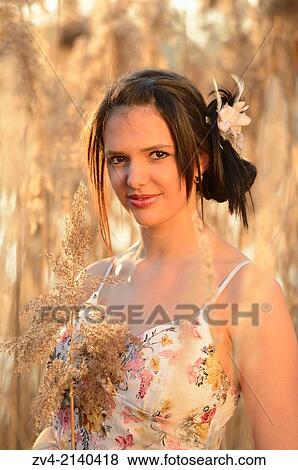 Portrait of a good looking young woman in the reeds at sunset in early spring. View Large Photo Image Stock Photo - Portrait of a good looking young woman in the reeds at sunset in early spring.. Fotosearch