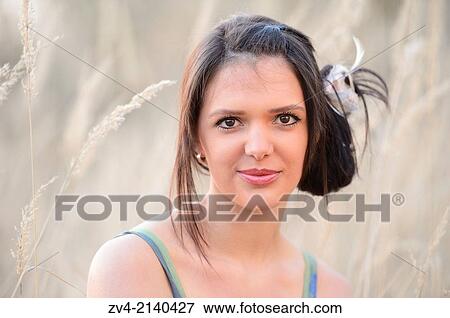Portrait of a good looking young woman in the grass in early spring. View Large Photo Image Stock Photo - Portrait of a good looking young woman in the grass in early spring.. Fotosearch