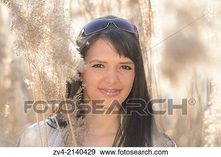 Portrait of a good looking young woman in the reeds on a sunny day in early spring. View Large Photo Image Stock Photo - Portrait of a good looking young woman in the reeds on a sunny day in early spring.. Fotosearch