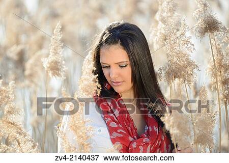 Portrait of a good looking young woman in the reeds on a sunny day in early spring. View Large Photo Image Stock Photo - Portrait of a good looking young woman in the reeds on a sunny day in early spring.. Fotosearch