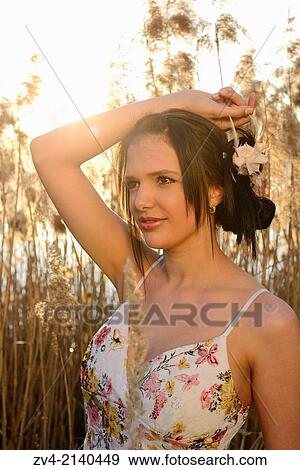 Portrait of a good looking young woman in the reeds at sunset in early spring. View Large Photo Image Stock Photo - Portrait of a good looking young woman in the reeds at sunset in early spring.. Fotosearch