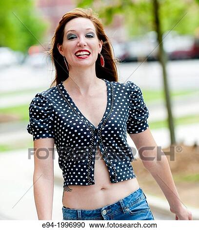 Portrait of a happy 31 year old red headed woman in an urban setting wearing jeans and a mid drift top. View Large Photo Image Stock Image - Portrait of a happy 31 year old red headed woman in an urban setting wearing jeans and a mid drift top.. Fotosearch