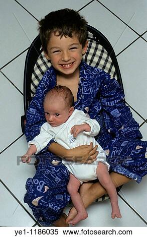 Portrait of a happy boy holding his new baby sister for the first time. View Large Photo Image Stock Photography - Portrait of a happy boy holding his new baby sister for the first time.. Fotosearch