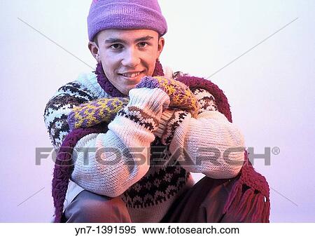 Stock Photography - portrait of a happy teenage boy rugged up against the cold of his snowy surrounds in the glow of the setting sun. Fotosearch