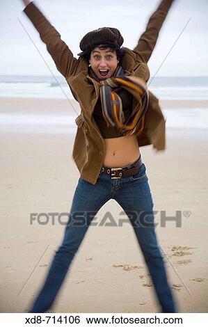 Stock Photograph - Portrait of a happy young woman jumping. Fotosearch