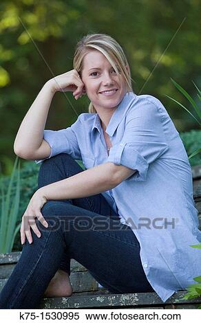 Stock Photography - Portrait of a happy young woman outdoors. Fotosearch