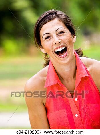 Portrait of a laughing 27 year old brunette woman looking at the camera with her mouth open wide, outdoors. View Large Photo Image Stock Photo - Portrait of a laughing 27 year old brunette woman looking at the camera with her mouth open wide, outdoors.. Fotosearch