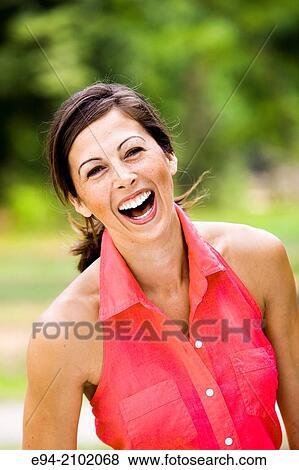 Portrait of a laughing 27 year old brunette woman looking at the camera with her mouth open wide, outdoors. View Large Photo Image Stock Photo - Portrait of a laughing 27 year old brunette woman looking at the camera with her mouth open wide, outdoors.. Fotosearch