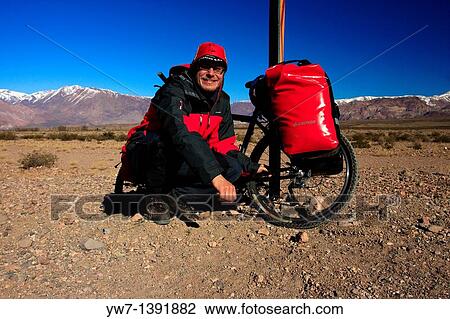 Portrait of a man cycling on an unpaved road in the Andes in Argentina in the vicinity of Uspallata village View Large Photo Image Stock Image - Portrait of a man cycling on an unpaved road in the Andes in Argentina in the vicinity of Uspallata village. Fotosearch