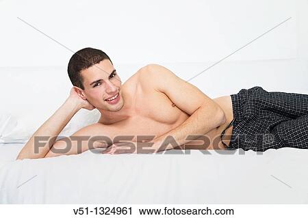 Portrait of a man laying in bed smiling at camera View Large Photo Image Stock Image - Portrait of a man laying in bed smiling at camera. Fotosearch