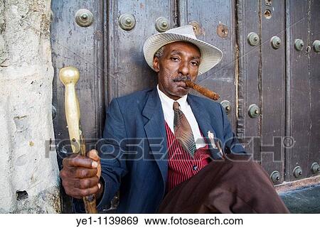 Portrait of a man wearing a 1930s-style suit and smoking a cigar, Havana Cuba. View Large Photo Image Stock Photo - Portrait of a man wearing a 1930s-style suit and smoking a cigar, Havana Cuba.. Fotosearch