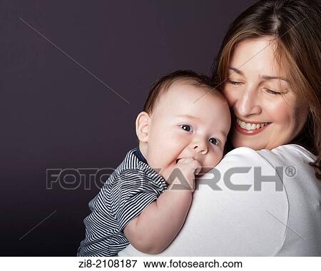 Stock Photo - Portrait of a mother with her baby, studio shot. Fotosearch