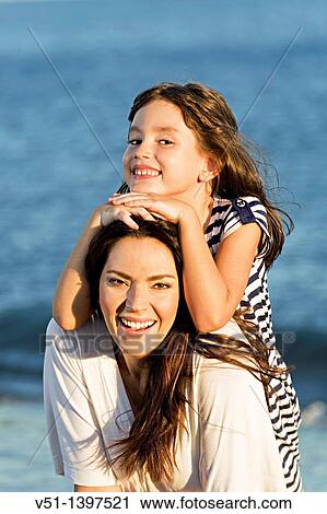 Portrait of a mother with her daughter smiling at the beach View Large Photo Image Stock Image - Portrait of a mother with her daughter smiling at the beach. Fotosearch