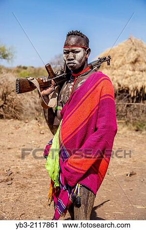 Portrait Of A Mursi Man Holding a Gun, Mursi Tribal Village, The Omo Valley, Ethiopia. View Large Photo Image Stock Image - Portrait Of A Mursi Man Holding a Gun, Mursi Tribal Village, The Omo Valley, Ethiopia.. Fotosearch