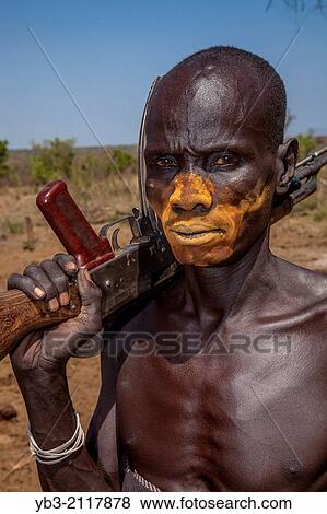Portrait Of A Mursi Man Holding a Gun, Mursi Tribal Village, The Omo Valley, Ethiopia. View Large Photo Image Stock Photo - Portrait Of A Mursi Man Holding a Gun, Mursi Tribal Village, The Omo Valley, Ethiopia.. Fotosearch