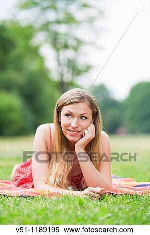 Stock Photography - Portrait of a pensive smiling woman in the park. Fotosearch