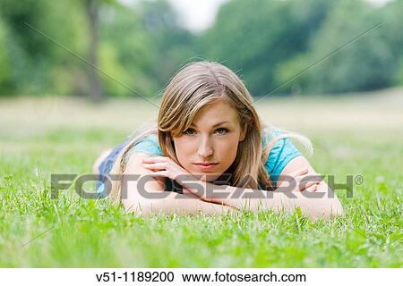 Portrait of a pensive woman lying down in park looking at camera View Large Photo Image Stock Image - Portrait of a pensive woman lying down in park looking at camera. Fotosearch
