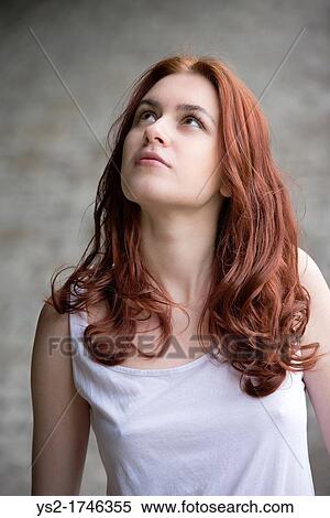 Portrait of a pensive young woman with red hair looking up View Large Photo Image Stock Photography - Portrait of a pensive young woman with red hair looking up. Fotosearch