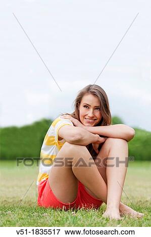 Stock Photo - Portrait of a pretty young woman relaxing in park. Fotosearch
