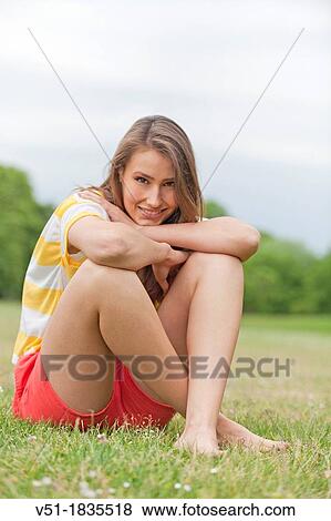 Stock Photo - Portrait of a pretty young woman relaxing in park. Fotosearch