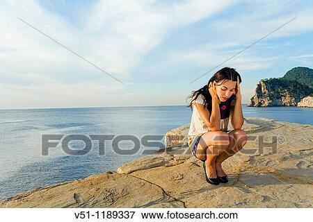 Stock Photo - Portrait of a sad woman in a l cliff. Fotosearch