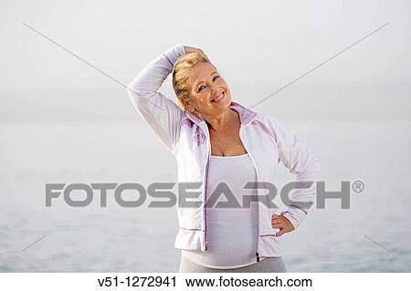Portrait of a senior adult woman stretching her neck at the beach View Large Photo Image Stock Image - Portrait of a senior adult woman stretching her neck at the beach. Fotosearch