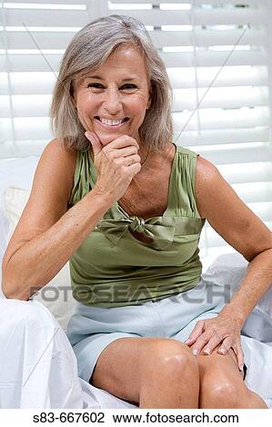Portrait of a senior woman smilling sitting on a chair View Large Photo Image Stock Image - Portrait of a senior woman smilling sitting on a chair. Fotosearch