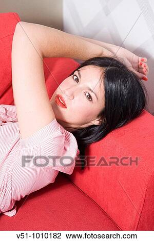 Portrait of a sensual brunette woman on the couch looking at camera View Large Photo Image Stock Image - Portrait of a sensual brunette woman on the couch looking at camera. Fotosearch