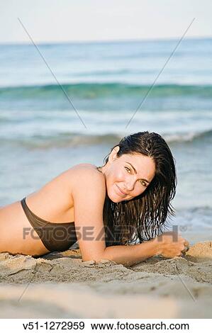 Portrait of a sensual brunette woman lokking at camera at the beach View Large Photo Image Stock Photo - Portrait of a sensual brunette woman lokking at camera at the beach. Fotosearch