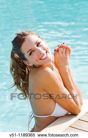 Stock Photography - Portrait of a sexy blonde woman enjoying summer holiday in pool. Fotosearch