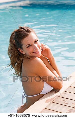 Stock Photography - Portrait of a sexy blonde woman enjoying summer holiday in pool. Fotosearch
